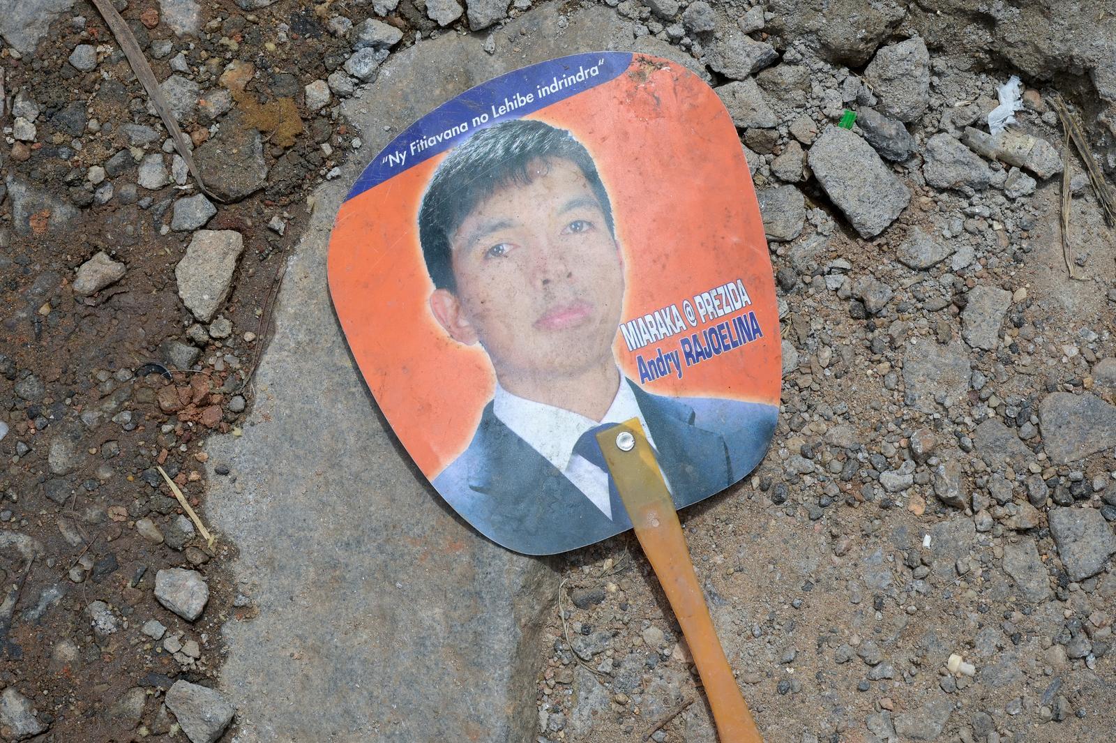 Ein Fan-Paddle mit dem Konterfei von Andry Rajoelina liegt auf der Straße.
